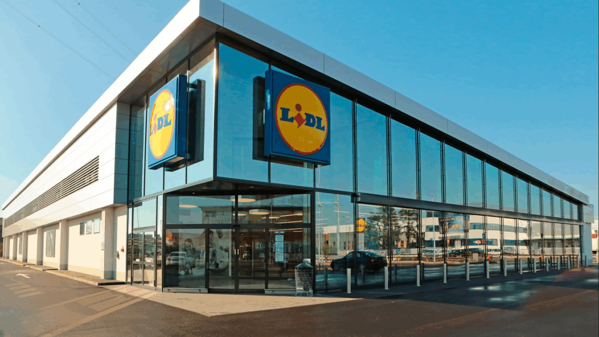 Exterior of a modern Lidl grocery store with glass facade and branded signage