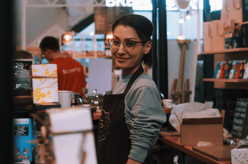 A convenience store worker smiling at the camera