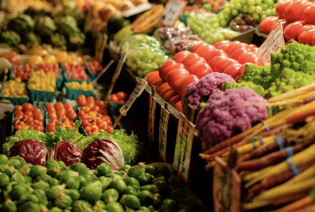 Densely stacked fruit and vegetable display with produce layered deep in boxes and punnets.