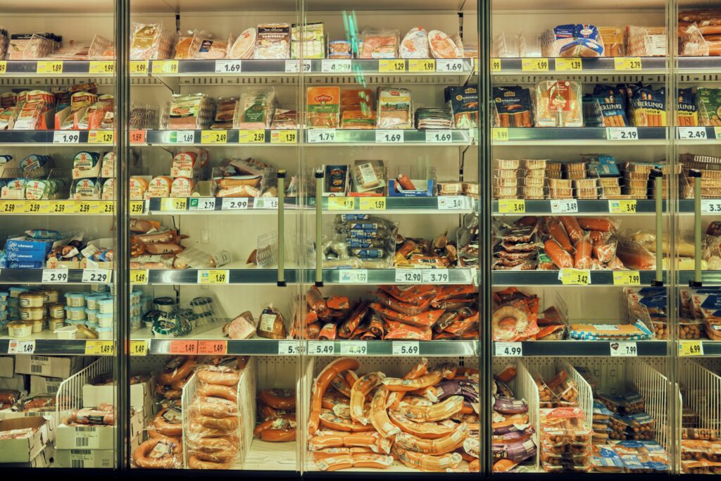 Chilled supermarket display case holding packaged deli meats under temperature control