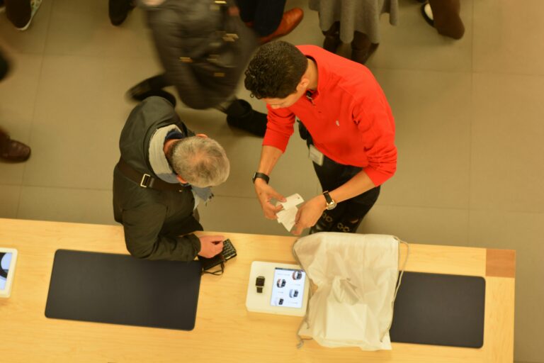 Store associate checking a customer’s receipt at a counter during a busy period in a retail store